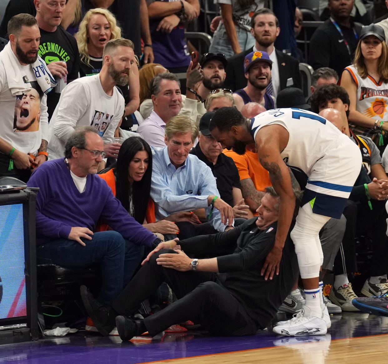 Apr 28, 2024; Phoenix, Arizona, USA; Minnesota Timberwolves guard Mike Conley (10) tends to to head coach Chris Finch after he was injured during the second half of game four of the first round for the 2024 NBA playoffs against the Phoenix Suns at Footprint Center. Mandatory Credit: Joe Camporeale-USA TODAY Sports
