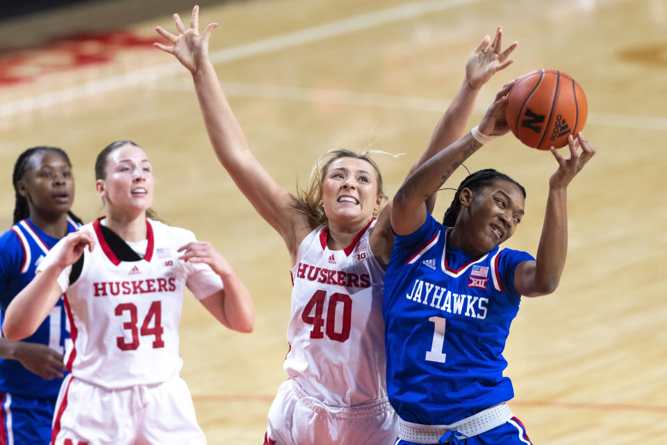 Kansas' Taiyanna Jackson (1) grabs a rebound next to Nebraska's Alexis Markowski (40) during the first half of an NCAA college basketball game Wednesday, Dec. 21, 2022, in Lincoln, Neb. (Kenneth Ferriera/Lincoln Journal Star via AP)