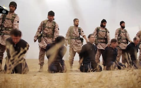 Members of Isil preparing the beheadings of at least 15 men described as Syrian troops - Credit: al-Furqan