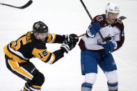 Pittsburgh Penguins' Josh Archibald (15) and Colorado Avalanche's Logan O'Connor compete for puck possession during the first period of an NHL hockey game in Pittsburgh, Tuesday, Feb. 7, 2023. (AP Photo/Gene J. Puskar)