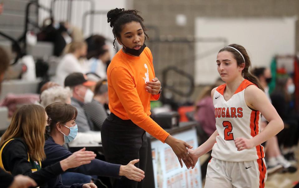 Central Kitsap girls basketball coach Ashli Payne, left, and senior Hailey Carroll slap hands during the Cougars' victory over Capital on Wednesday.