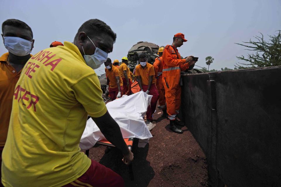 Rescuers carry the body of a victim of a passenger train that derailed in Balasore district, in the eastern Indian state of Orissa, Saturday, June 3, 2023. Rescuers are wading through piles of debris and wreckage to pull out bodies and free people after two passenger trains derailed in India, killing more than 280 people and injuring hundreds as rail cars were flipped over and mangled in one of the country’s deadliest train crashes in decades. (AP Photo/Rafiq Maqbool)