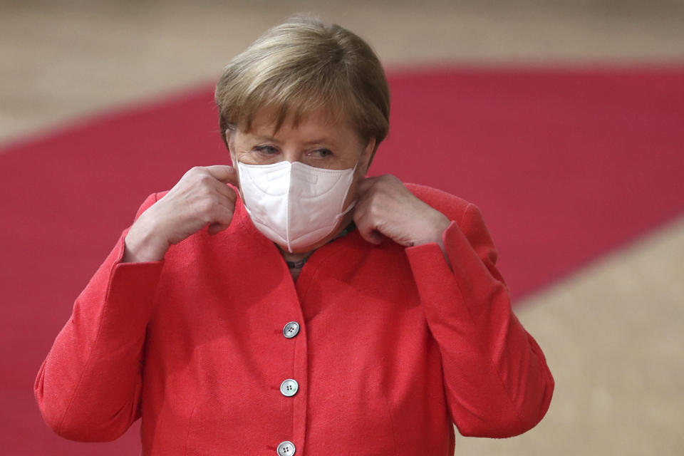 German Chancellor Angela Merkel prepares to remove her protective face mask prior to deliver a speech  as she arrives for a European Union Council in Brussels on July 17, 2020, as the leaders of the European Union hold their first face-to-face summit over a post-virus economic rescue plan. - The EU has been plunged into a historic economic crunch by the coronavirus crisis, and EU officials have drawn up plans for a huge stimulus package to lead their countries out of lockdown. (Photo by Francisco Seco / POOL / AFP) (Photo by FRANCISCO SECO/POOL/AFP via Getty Images)