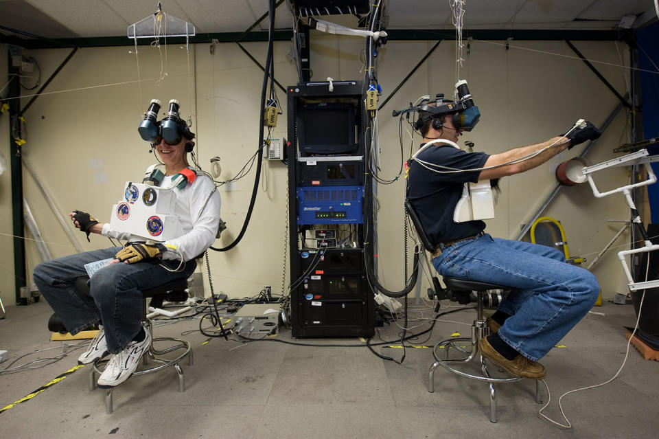 Astronauts Clayton Anderson and Rick Mastracchio, STS-131 mission specialists, use virtual reality hardware to rehearse duties planned for their ISS visit.
