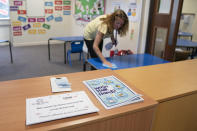 Reception teacher Elizabeth Dockry cleans her classroom as measures are taken to prevent the transmission of coronavirus before the possible reopening of Lostock Hall Primary school in Poynton near Manchester, England, Wednesday May 20, 2020. (AP Photo/Jon Super)