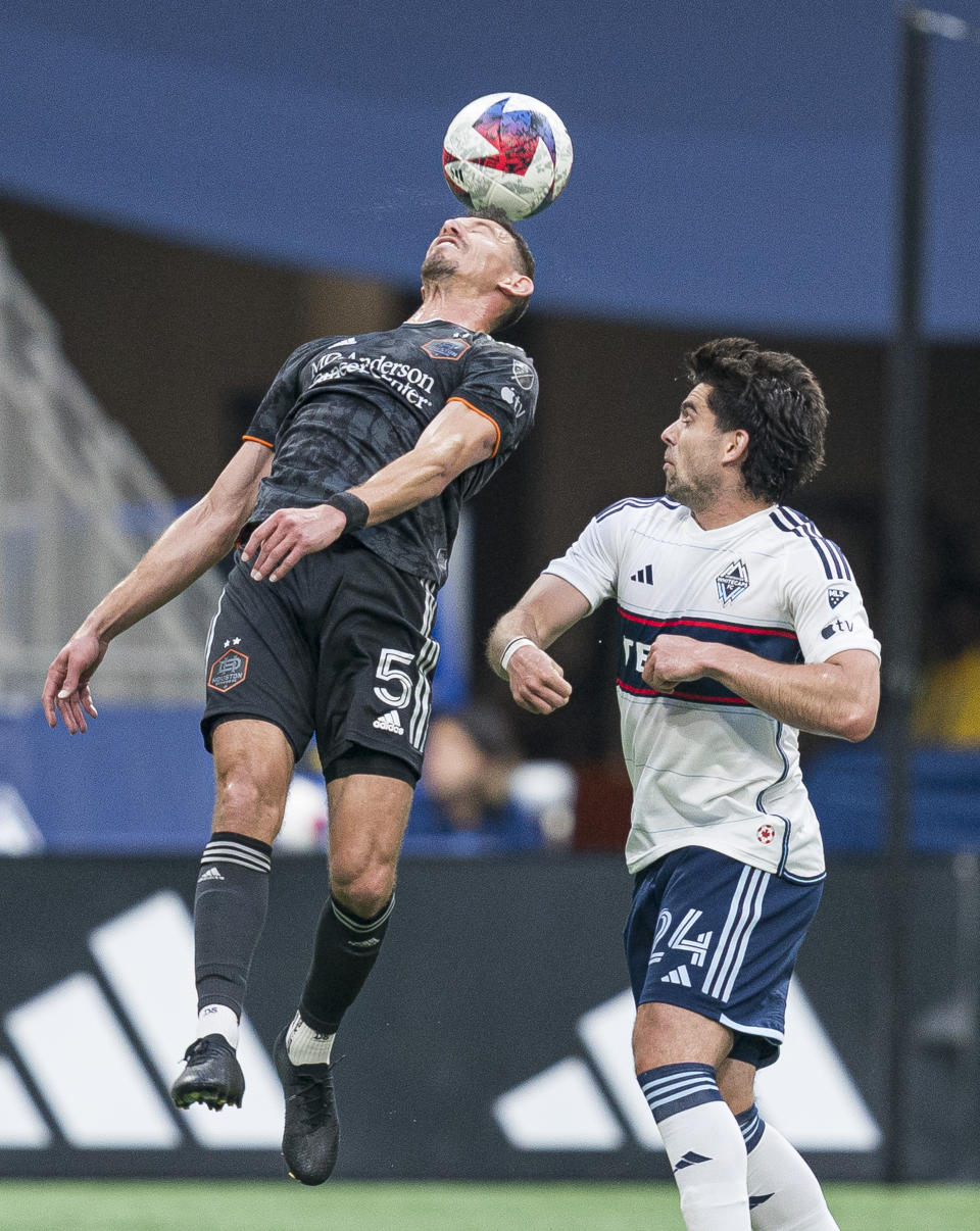 Houston Dynamo's Daniel Steres, left, gets his head on the ball while Vancouver Whitecaps' Brian White watches during the first half of an MLS soccer match Wednesday, May 31, 2023, in Vancouver, British Columbia. (Rich Lam/The Canadian Press via AP)