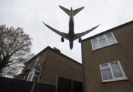 FILE PHOTO: An aircraft passes over houses as it lands at Heathrow Airport near London, Britain, December 11, 2015. REUTERS/Neil Hall/File Photo