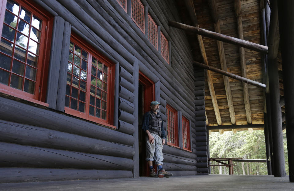 In this Tuesday, July 30, 2013 photo, master carpenter Michael Frenette poses in a doorway of the main lodge at Camp Santanoni, an Adirondack great camp that is being restored, in Newcomb, N.Y. Santanoni was one of the earliest great camps built by wealthy families with names like Rockefeller and Vanderbilt beginning in the late 19th century. Managed by state environmental officials, it is the only remaining great camp that is publicly owned. (AP Photo/Mike Groll)
