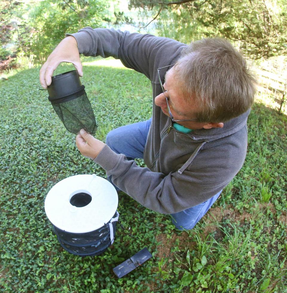 A Shawnee County Health Department employee checks a trap that department maintains to monitor the presence of mosquitoes.