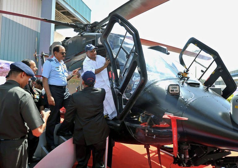 Indian defense minister A.K. Antony (R) gets into the cockpit of a HAL Rudra helicopter during Aero India 2013 at the Yelahanka Air Force station in Bangalore on February 6, 2013. The government is forcing foreign arms suppliers to share their technology with HAL in the hope that it can one day manufacture its own products of the same calibre