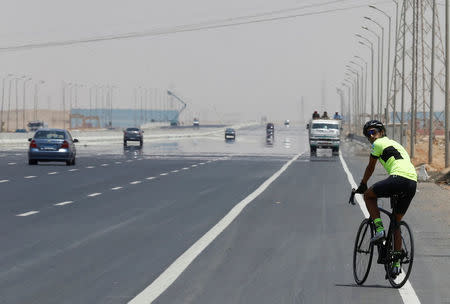 Egyptian cyclist Helmy El Saeed, 27, rides his bicycle on the highway of El Ain El Sokhna, east of Cairo, Egypt July 19, 2017. El Saeed has become a Guinness record holder after partaking in the fastest ever Europe bicycle cross. Picture taken July 19, 2017. REUTERS/Amr Abdallah Dalsh