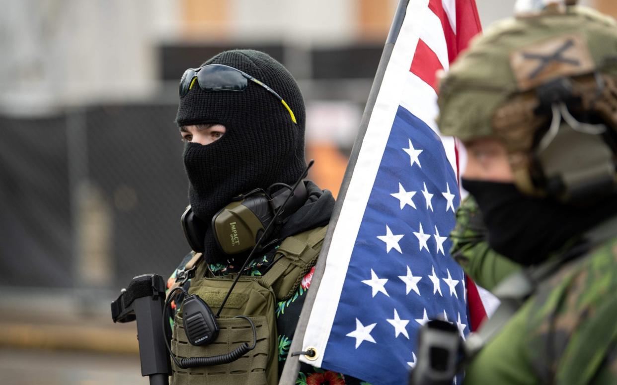 Members of the Boogaloo Boys stand armed in front of the Oregon Sate Capitol building in Salem - AFP