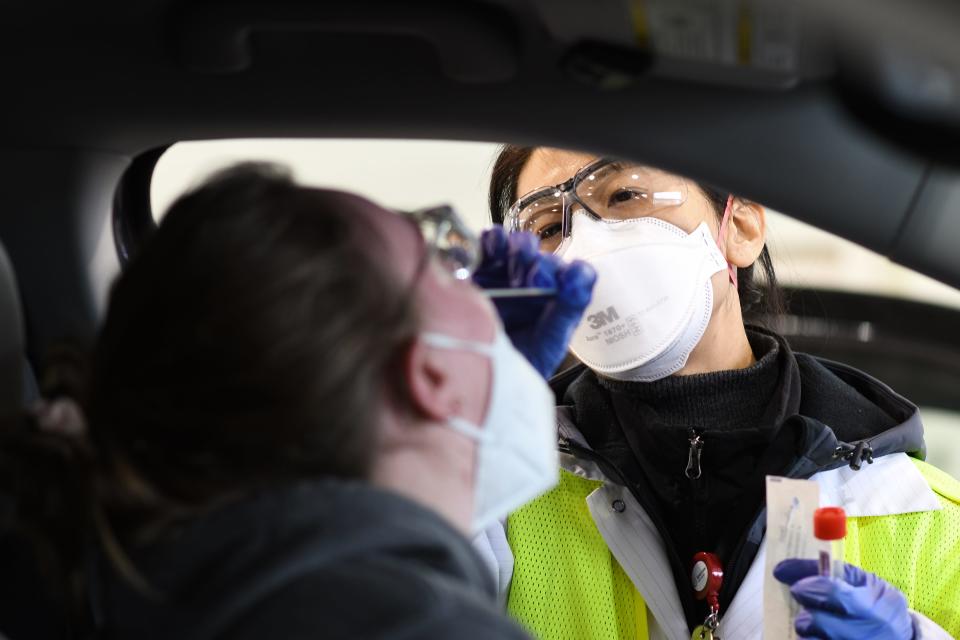 Sparrow Healthcare phlebotomist Jayoung Kim takes a nasal swab from MSU student Jessie Munson of Milford Wednesday, Jan. 12, 2022, at Sparrow Drive-Thru Services in Frandor. Sparrow has performed over 250,000 tests for COVID-19 at the center.
