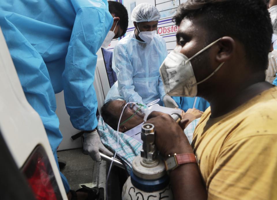 Health workers shift a patient after a fire in Vijay Vallabh COVID-19 hospital at Virar, near Mumbai, India, Friday, April 23, 2021. A fire killed 13 COVID-19 patients in a hospital in western India early Friday as an extreme surge in coronavirus infections leaves the nation short of medical care and oxygen. (AP Photo/Rajanish Kakade)