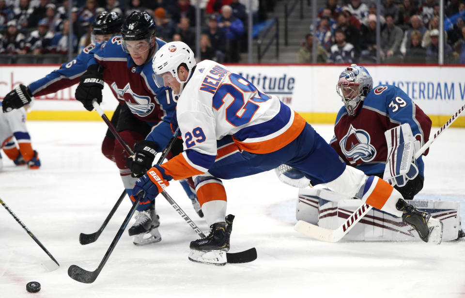 Colorado Avalanche defenseman Nikita Zadorov, left, fights for control of the puck with New York Islanders center Brock Nelson, center, as Colorado goaltender Pavel Francouz protects the net during the second period of an NHL hockey game Wednesday, Feb. 19, 2020, in Denver. (AP Photo/David Zalubowski)