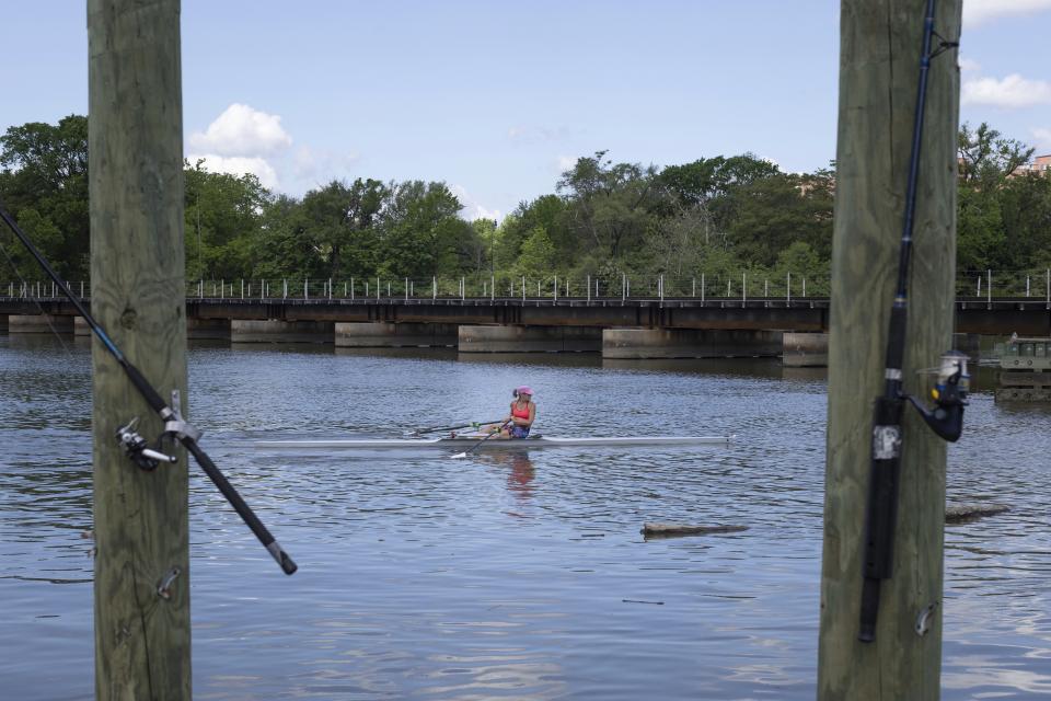 A person rows a boat along the Anacostia River on Wednesday, May 1, 2024, near Anacostia Park in Washington. For decades, the Anacostia was treated as a municipal dumping ground for industrial waste, storm sewers and trash. A sewer upgrade in the city and decades of local environmental advocacy have brought improvements to the river, but change has come slowly. (AP Photo/Tom Brenner)