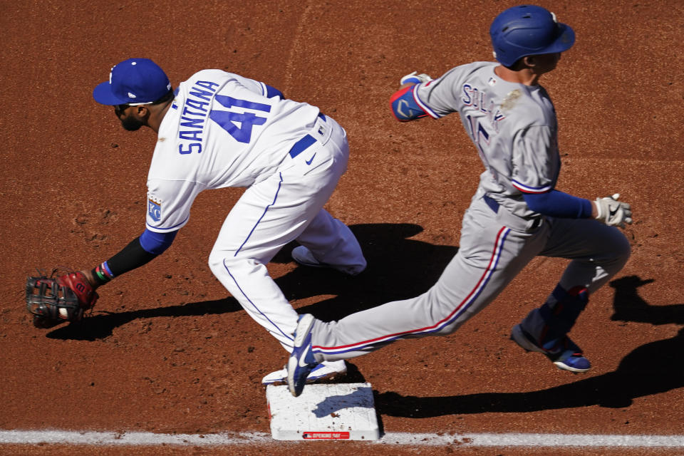 Texas Rangers' Nick Solak (15) beats the throw to Kansas City Royals first baseman Carlos Santana (41) for an RBI single during the first inning of a baseball game Thursday, April 1, 2021, in Kansas City, Mo. (AP Photo/Charlie Riedel)