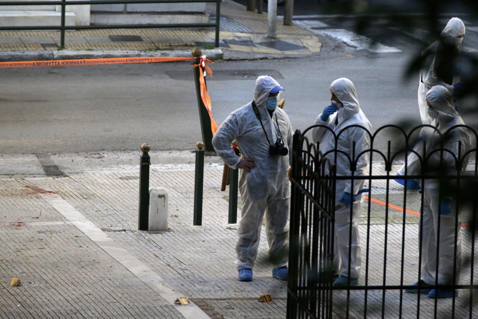 Greek forensic experts search at the scene after an explosion outside the Orthodox church of Agios Dionysios in the upscale Kolonaki area of Athens, Thursday, Dec. 27, 2018. Police in Greece say an officer has been injured in a small explosion outside a church in central Athens while responding to a call to investigate a suspicious package.(AP Photo/Thanassis Stavrakis)