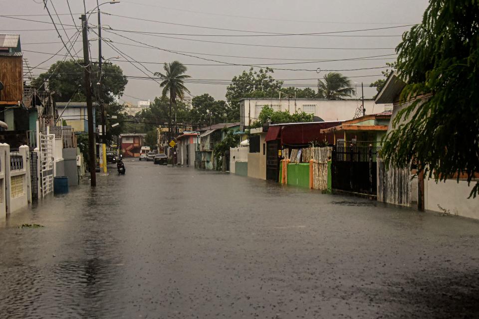 A flooded road is seen during the passage of hurricane Fiona in Villa Blanca, Puerto Rico, on 18 September 2022 (AFP via Getty Images)