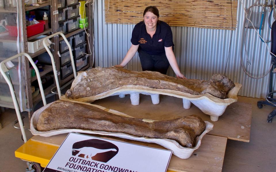 Rochelle Lawrence with a giant fossilised bone  - SCOTT HOCKNULL/The Eromanga Natural History Mus/AFP via Getty Images