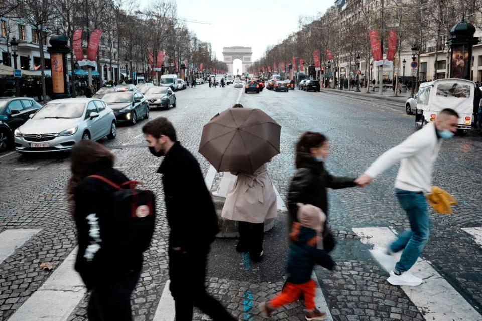 People crossing the Champs Elysees Avenue in Paris on Tuesday (AP)