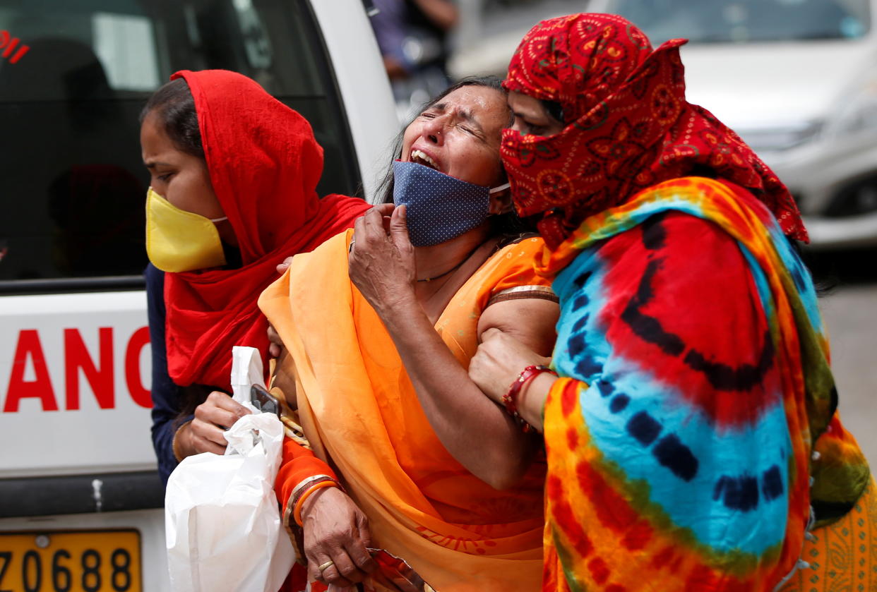 A woman is consoled after her husband died due to the coronavirus disease (COVID-19) outside a mortuary of a COVID-19 hospital in Ahmedabad, India, April 20, 2021. (Amit Dave/Reuters)