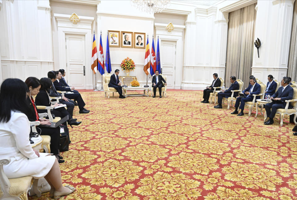 In this photo provided by Kok Ky/Cambodia's Government Cabinet, Cambodian Prime Minister Hun Sen, center right, talks with Chinese Foreign Minister Wang Yi, center left, during a meeting in Peace Palace in Phnom Penh, Cambodia, Sunday, Aug. 13, 2023. (Kok Ky/Cambodia's Government Cabinet via AP)