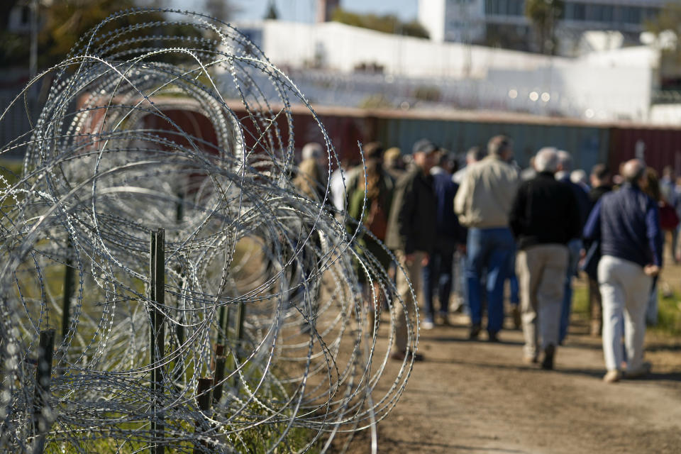 Concertina wire lines the path as members of Congress tour an area near the Texas-Mexico border, Wednesday, Jan. 3, 2024, in Eagle Pass, Texas. U.S. House Speaker Mike Johnson is leading about 60 fellow Republicans in Congress on a visit to the Mexican border. Their trip comes as they are demanding hard-line immigration policies in exchange for backing President Joe Biden's emergency wartime funding request for Ukraine. (AP Photo/Eric Gay)