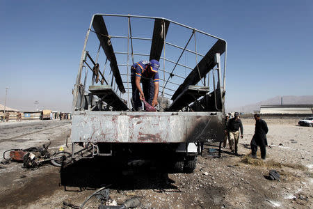 A rescue worker inspects as policemen gather near a truck after a blast in Quetta, Pakistan October 18, 2017. REUTERS/Naseer Ahmed