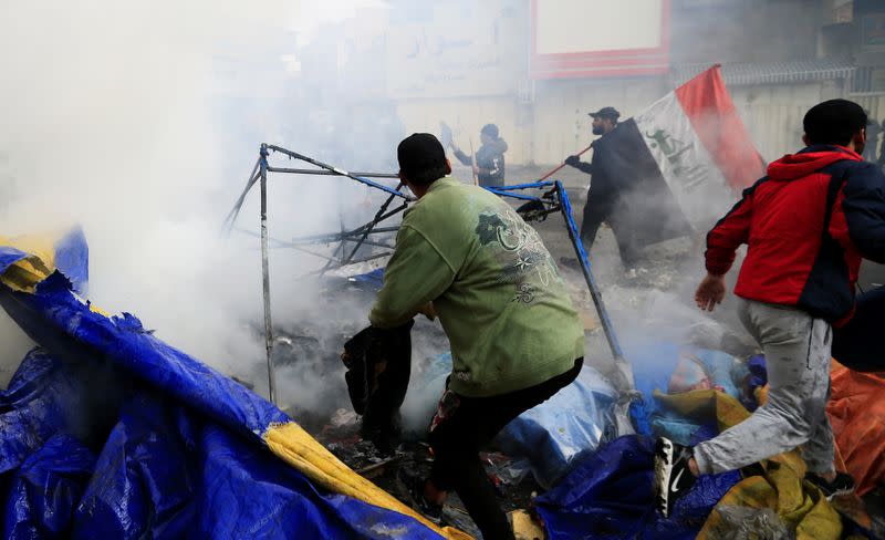 Smoke rises from burning tents as Iraqi security forces raid at Tahrir Square during ongoing anti-government protests in Baghdad