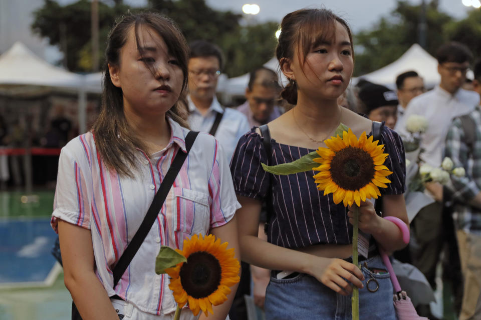 Attendees take part in a public memorial for Marco Leung, 35-year-old man, who fell to his death weeks ago after hanging a protest banner against an extradition bill, in Hong Kong, Thursday, July 11, 2019. The parents of a Hong Kong man who plunged to his death after putting up banners against divisive extradition bills have urged young people to stay alive to continue their struggle. (AP Photo/Kin Cheung)