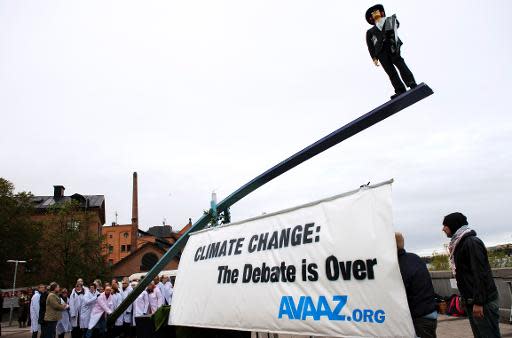 Concentración en apoyo del informe del IPCC sobre el cambio climático y la responsabilidad en él del ser humano, con una pancarta que reza "Se acabó el debate", este viernes en Estocolmo. (AFP | Jonathan Nackstrand)