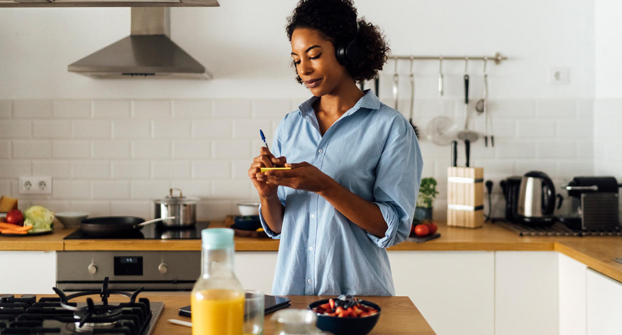 Woman writing list in morning at breakfast, to represent motivation. (Getty Images)