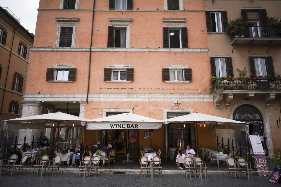 People sit at a restaurant in Piazza Navona, in Rome, Monday, Oct. 26, 2020. For at least the next month, people outdoors except for small children must now wear masks in all of Italy, gyms, cinemas, swimming pools, and movie theaters will be closed, ski slopes are off-limits to all but competitive skiers and cafes and restaurants must shut down in early evenings, under a decree signed on Sunday by Italian Premier Giuseppe Conte, who ruled against another severe lockdown despite a current surge in COVID-19 infections. (AP Photo/Andrew Medichini)