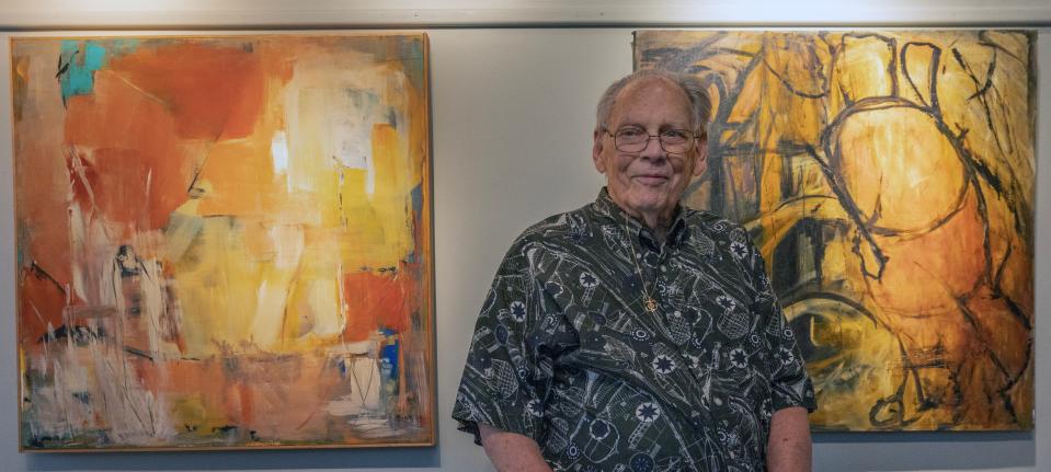 Harry Madsen stands in front of a display of artwork by his late wife Lorraine Madsen, who continued painting while battling cancer in spite of nerve damage to her hands from the chemo treatment. The display is at the Belmar Arts Council.
