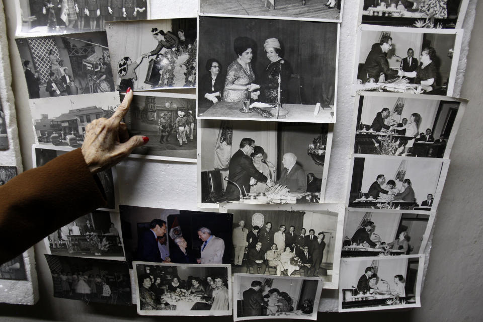 In this Nov. 26, 2012 photo, journalist and radio host Maria Julia Venegas, better known as Maruja Venegas, 97, points to pictures of herself during an interview at her home in Lima, Peru. Venegas who began broadcasting “Radio Club Infantil,” a show for Peru's children in the golden age of radio and World War II, has earned a citation from Guinness World Records as the globe's longest-running radio personality. (AP Photo/Karel Navarro)