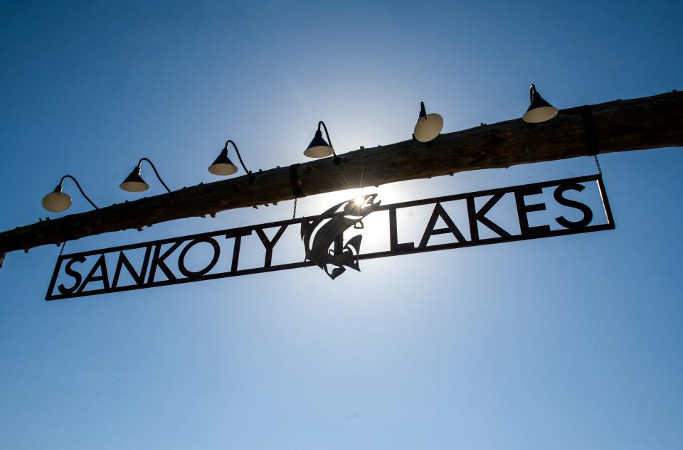 The sun shines through the Sankoty Lakes Resort logo hanging at the entrance to the shuttered property in Spring Bay.