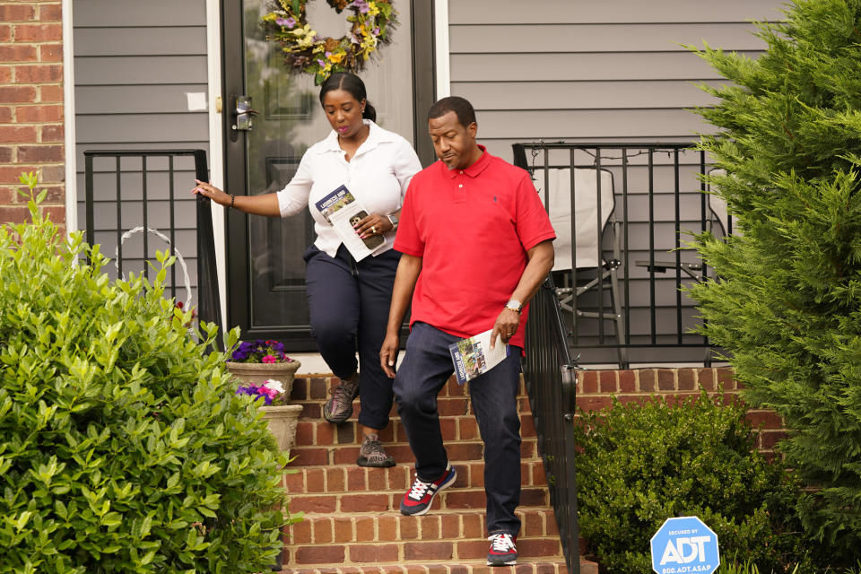 Former Delegate Lashrecse Aird, left, walks from a home with Henrico County supervisor, Tyrone Nelson, right, as they canvas a neighborhood, Monday, May 22, 2023, in Henrico County, Va. Aird is challenging State Sen. Joe Morrissey in a Democratic primary for a newly redrawn senatorial district. (AP Photo/Steve Helber)