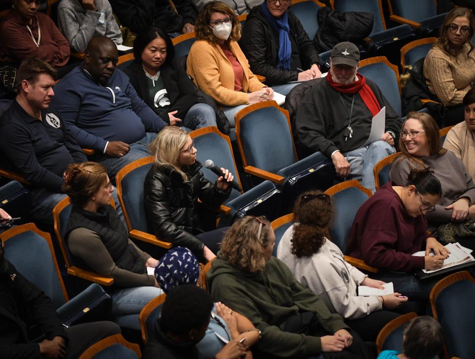 East Lansing High School senior Emily Walters, with microphone, speaks during a meeting Friday, Jan. 27, 2023, in response to violence at the school.