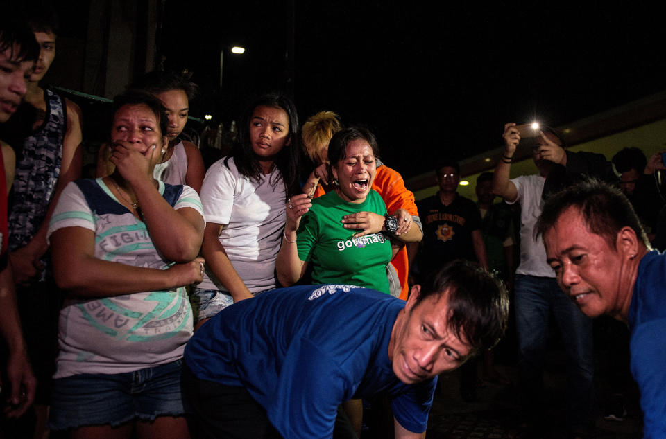 <p>Relatives cry as coroners carry away the body of an alleged drug dealer killed during a drug buy bust operation in Manila, Philippines, Jan. 5, 2017. (Noel Celis/AFP/Getty Images) </p>