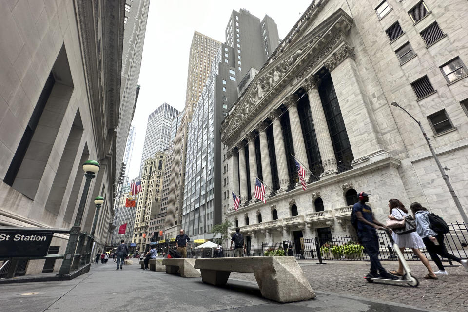 People pass the New York Stock Exchange on Tuesday, July 30, 2024 in New York. Wall Street is mixed as more companies post quarterly earnings numbers and the Federal Reserve prepares to convene its latest monetary policy meeting and talk about the future of rates in the U.S.(AP Photo/Peter Morgan)