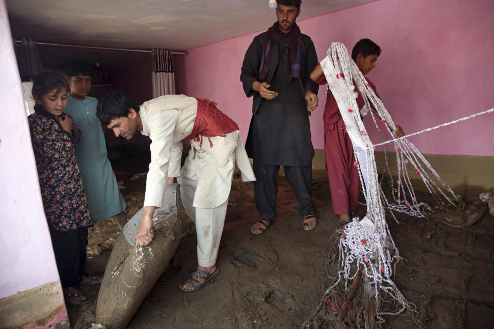 Afghans salvage belongings from their house that was damaged by a mudslide, in the Parwan province, north of Kabul, Afghanistan, Thursday, Aug. 27, 2020. The death toll from heavy flooding in northern and eastern Afghanistan rose to at least 150 on Thursday, with scores more injured as rescue crews searched for survivors beneath the mud and rubble of collapsed houses, officials said. (AP Photo/Rahmat Gul)