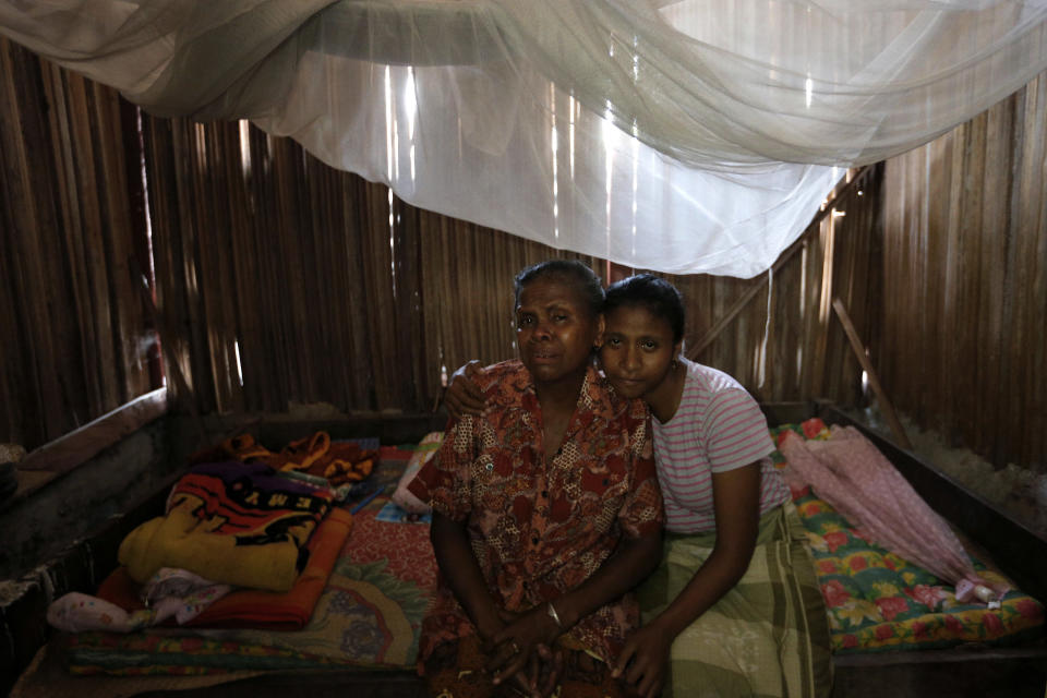 Yohanna Banunaek (izq) es consolada por su hija Yeti en el poblado de Abi, en Timor Occidental, Indonesia, el 21 de octubre del 2018. Su hija Adelina Sau fallació en febrero mientras trabajaba como empleada doméstica en Malasia. (AP Photo/Tatan Syuflana)