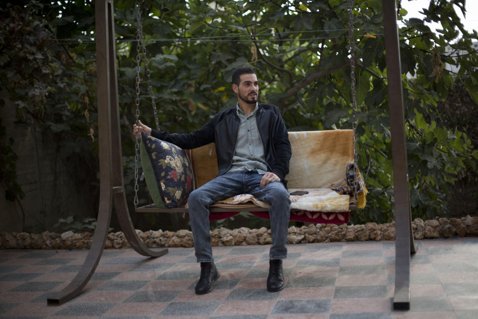 Palestinian Karam Qawasmi, who was shot in the back by Israeli forces in an incident caught on video last year, sits in his garden, in the West Bank city of Hebron, Sunday, Nov. 10, 2019. In his first interview since the video emerged last week, Karam Qawasmi said he was run over by a military jeep, then beaten for several hours before troops released him, only to shoot him in the back with a painful sponge-tipped bullet as he walked away. (AP Photo/Majdi Mohammed)