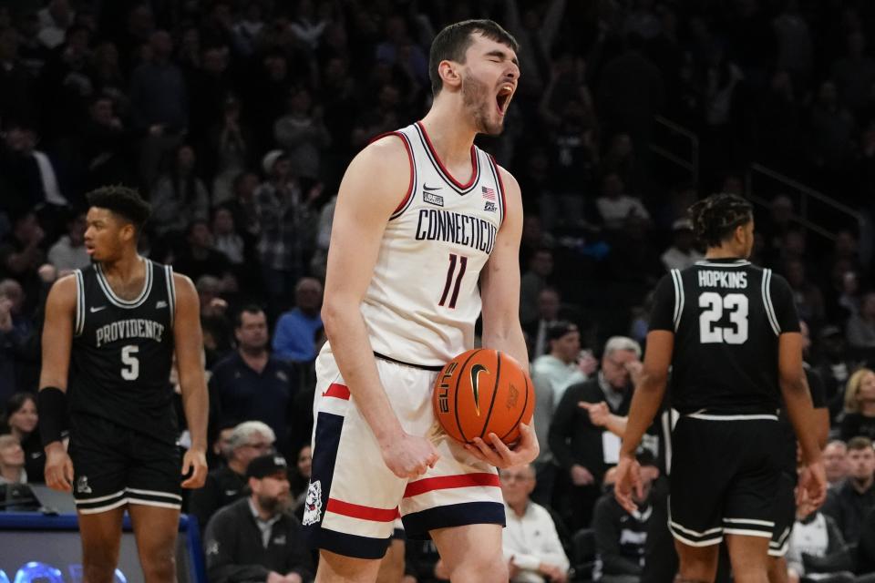 FILE - UConn's Alex Karaban (11) celebrates during the second half of an NCAA college basketball game as Providence's Ed Croswell (5) and Bryce Hopkins (23) react in the quarterfinals of the Big East Conference Tournament Thursday, March 9, 2023, in New York. UConn won 73-66. While Adama Sanogo, Jordan Hawkins and Andre Jackson are gone, the Huskies return a solid core built around 7-foot-2 sophomore Donovan Clingan and returning starters Alex Karaban and Tristen Newton. (AP Photo/Frank Franklin II, File)