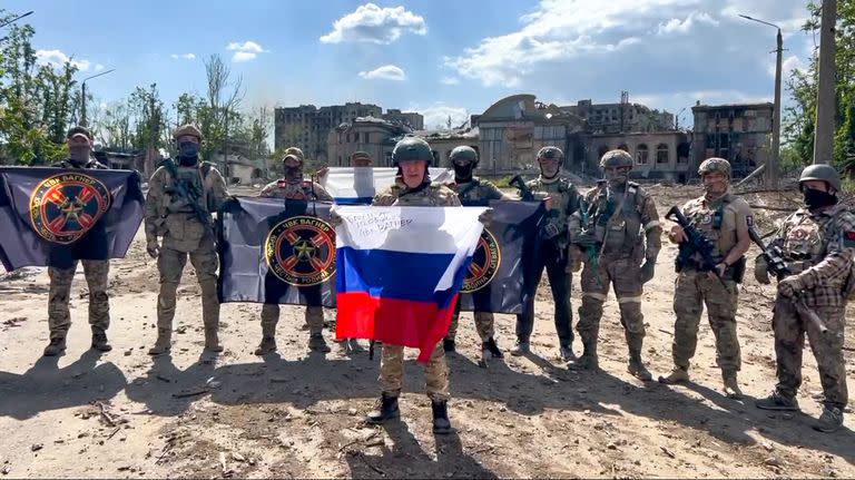 Yevgeny Prigozhin, jefe del grupo  Wagner sostiene una bandera nacional rusa delante de sus soldados en Bakhmut, Ucrania.