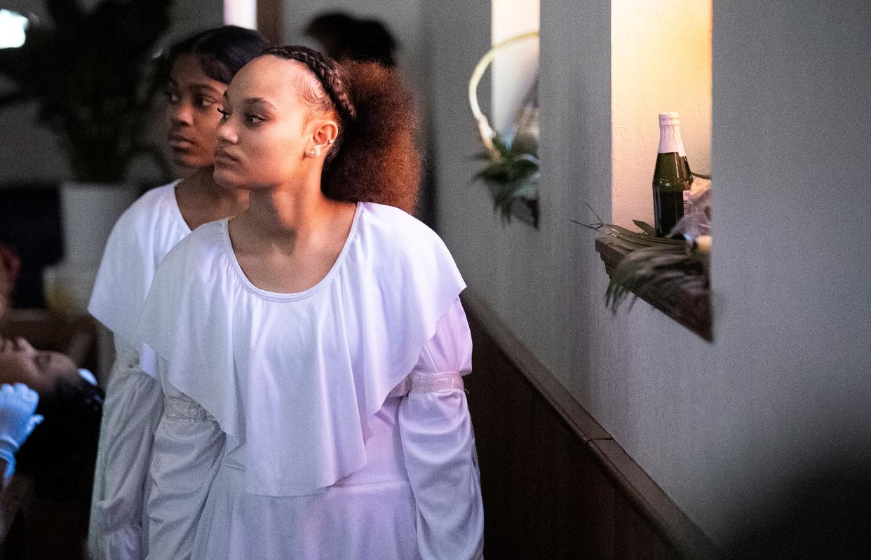 Sion Rone, 15, waits behind a pew for her cue to dance with the Butterflies and OSAO (Our Steps Are Ordered) Dance Ministry during a special Easter performance held on Palm Sunday, March 24, at the Family Missionary Baptist Church in Columbus.