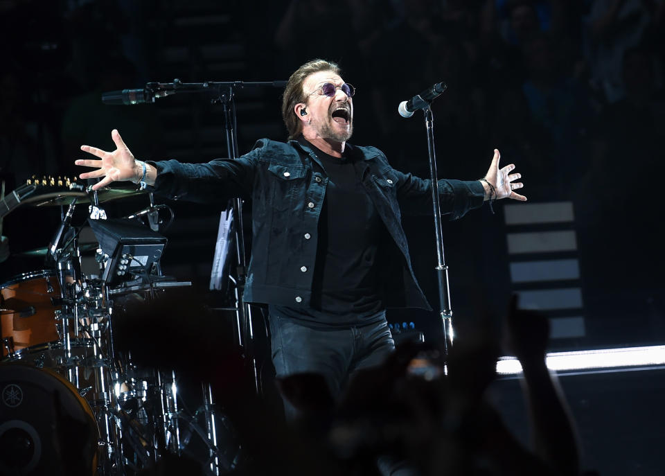 Bono from U2 performs in black outfit on stage