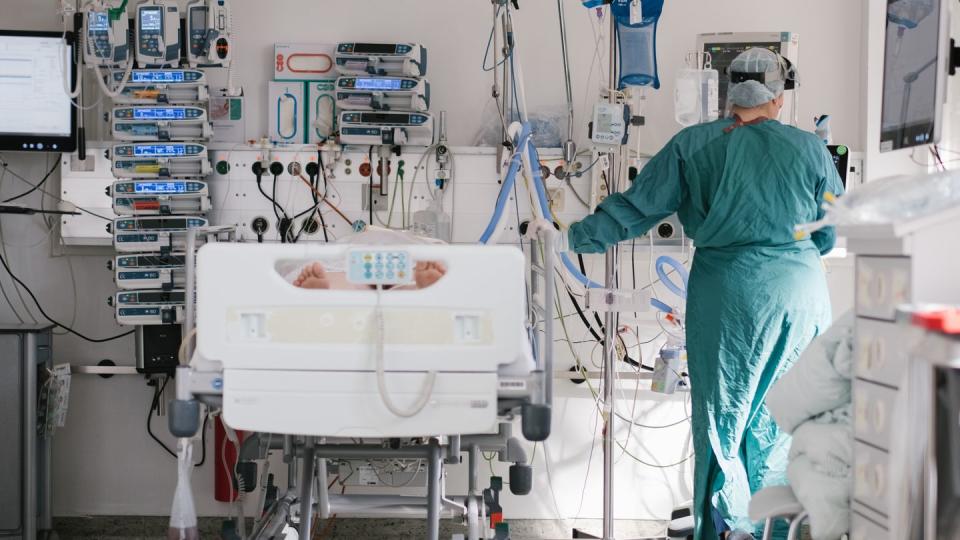 Eine Intensivpflegerin versorgt auf der Intensivstation einen an Covid-19 erkrankten Patienten.