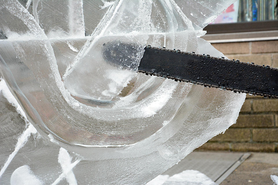 Closeup of someone using a saw on ice